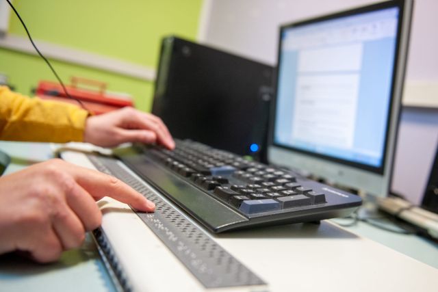 Deux mains sur un clavier d'ordinateur braille