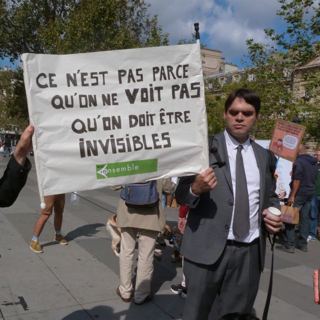 Notre président Matthieu Juglar lors d'une manifestation, tenant une pancarte "Ce n'est pas parce qu'on ne voit pas qu'on doit être invisibles"
