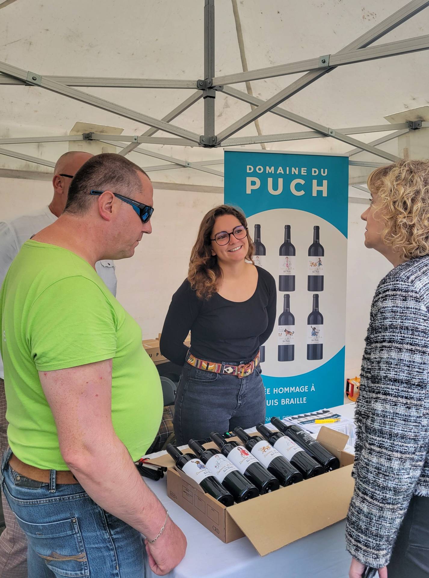 Camille notre commerciale de l'ESAT domaine du Puch présentant la cuvée hommage à Louis braille à notre directrice générale Carole Godin, avec l'un des travailleur de l'ESAT
